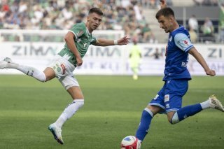 Adrian Bajrami (en bleu) dégage devant le Saint-Gallois Christian Witzig KEYSTONE/GIAN EHRENZELLER